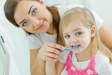 Mom and Daughter brushing their teeth - Pediatric Dentist in Memphis, TN